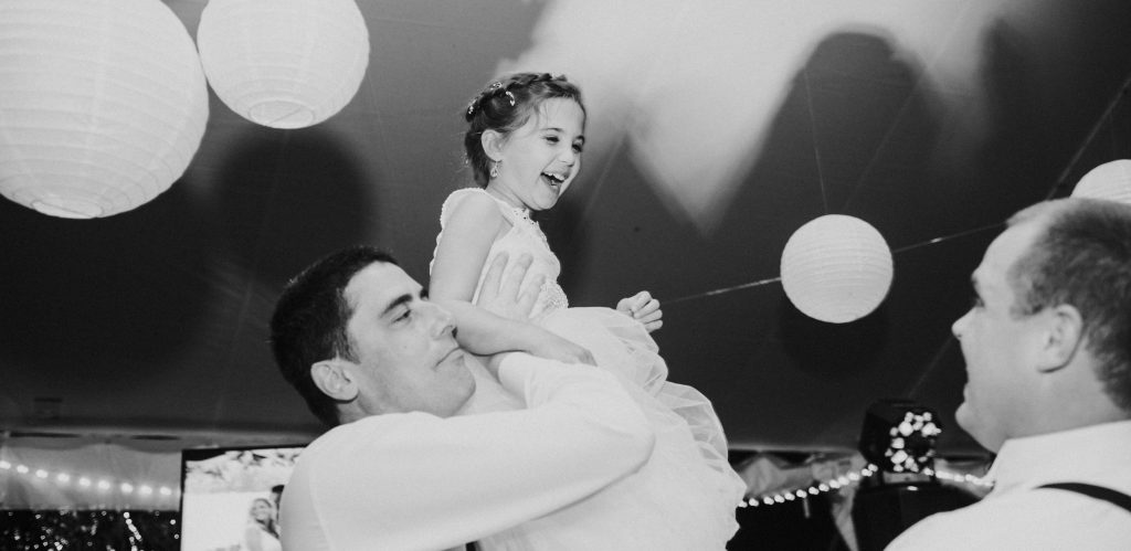 photo of groom holding up flower girl